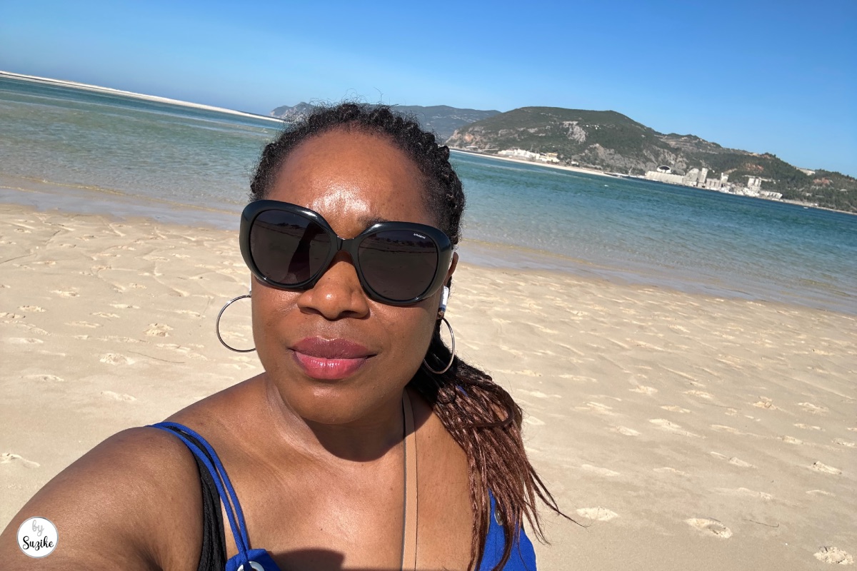 Suzike taking a beach selfie with calm sea and sand during a relaxing vacation in Troia Portugal