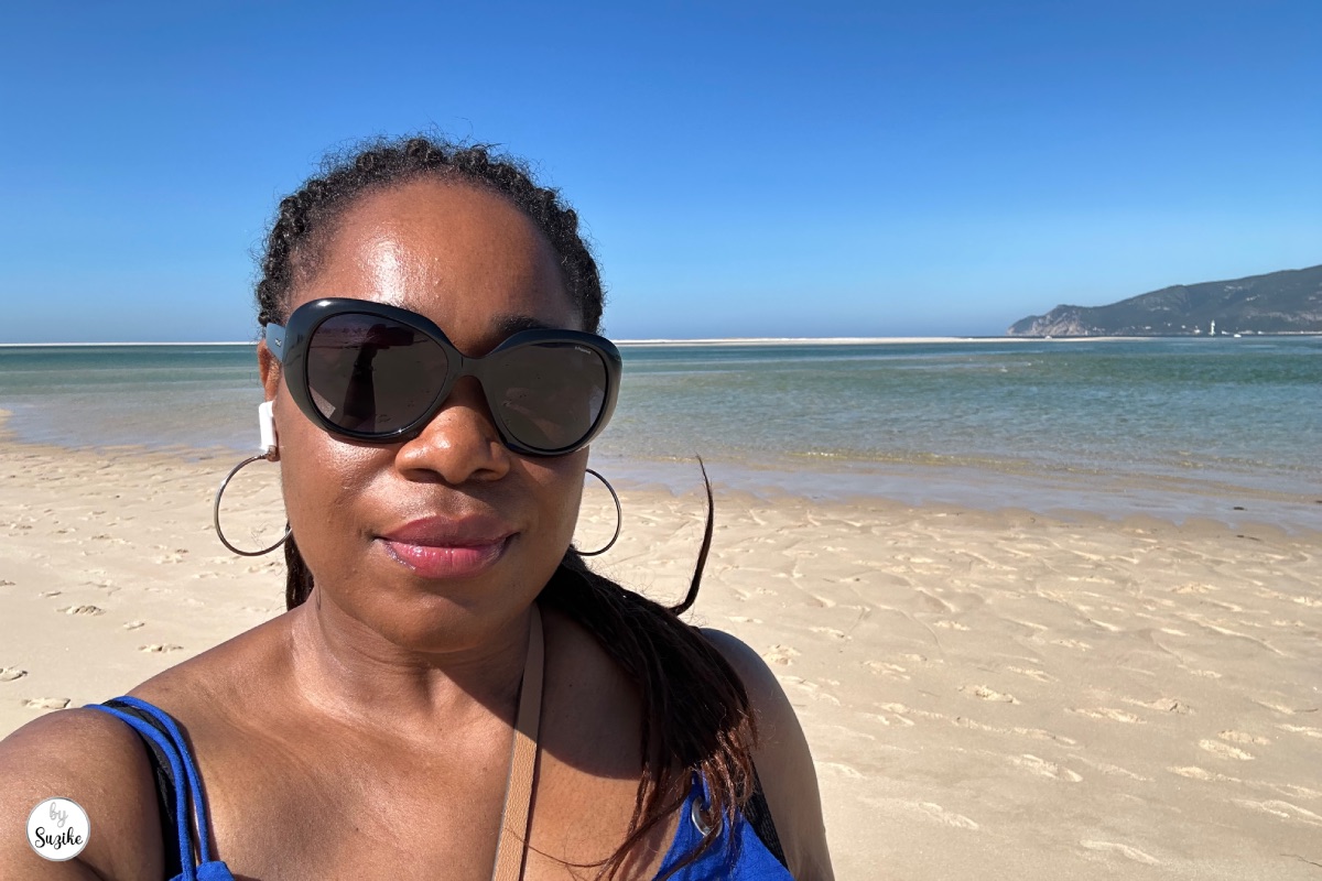 relaxing-vacation-troia-portugal-beach-02 Suzike wearing sunglasses on a sunny beach with clear blue water in Troia Portugal