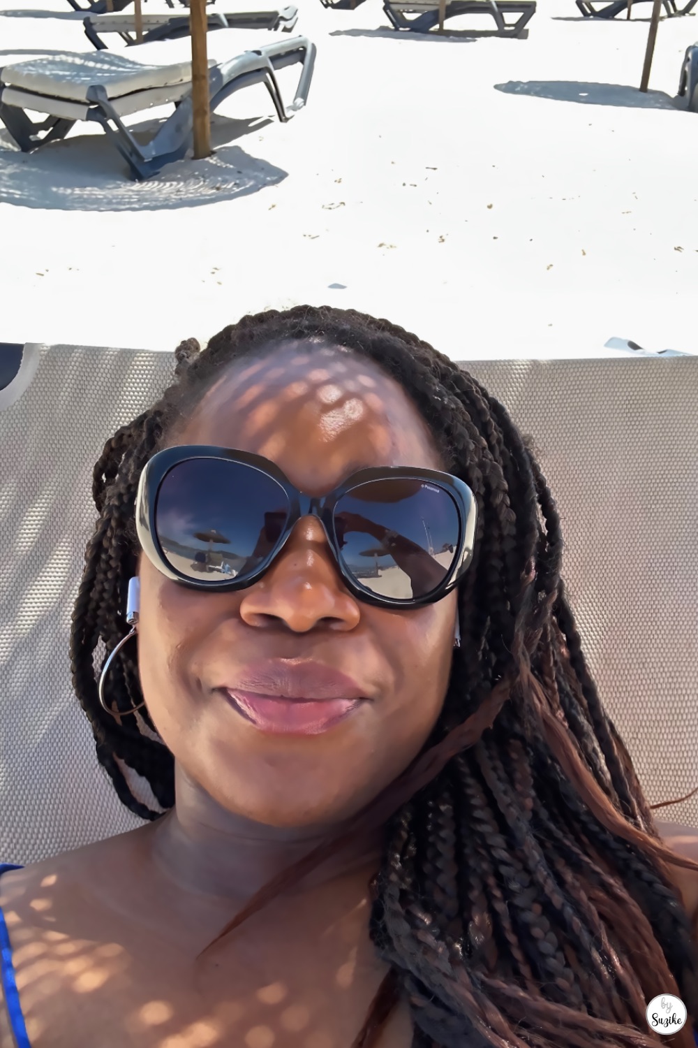 Suzike relaxing on a beach lounger with sunglasses during a sunny vacation in Troia Portugal