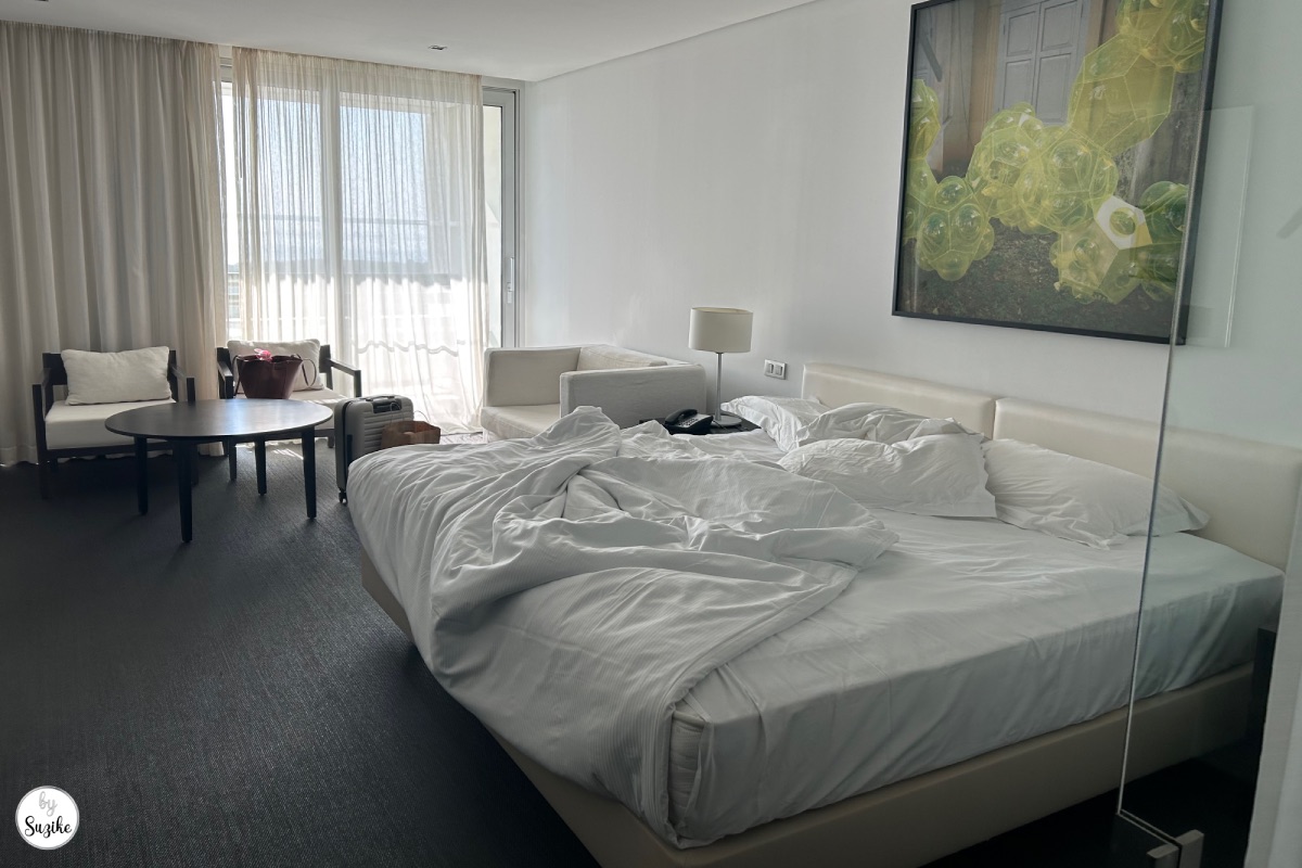 Bright hotel bedroom with white bed and modern decor during a relaxing vacation in Troia Portugal