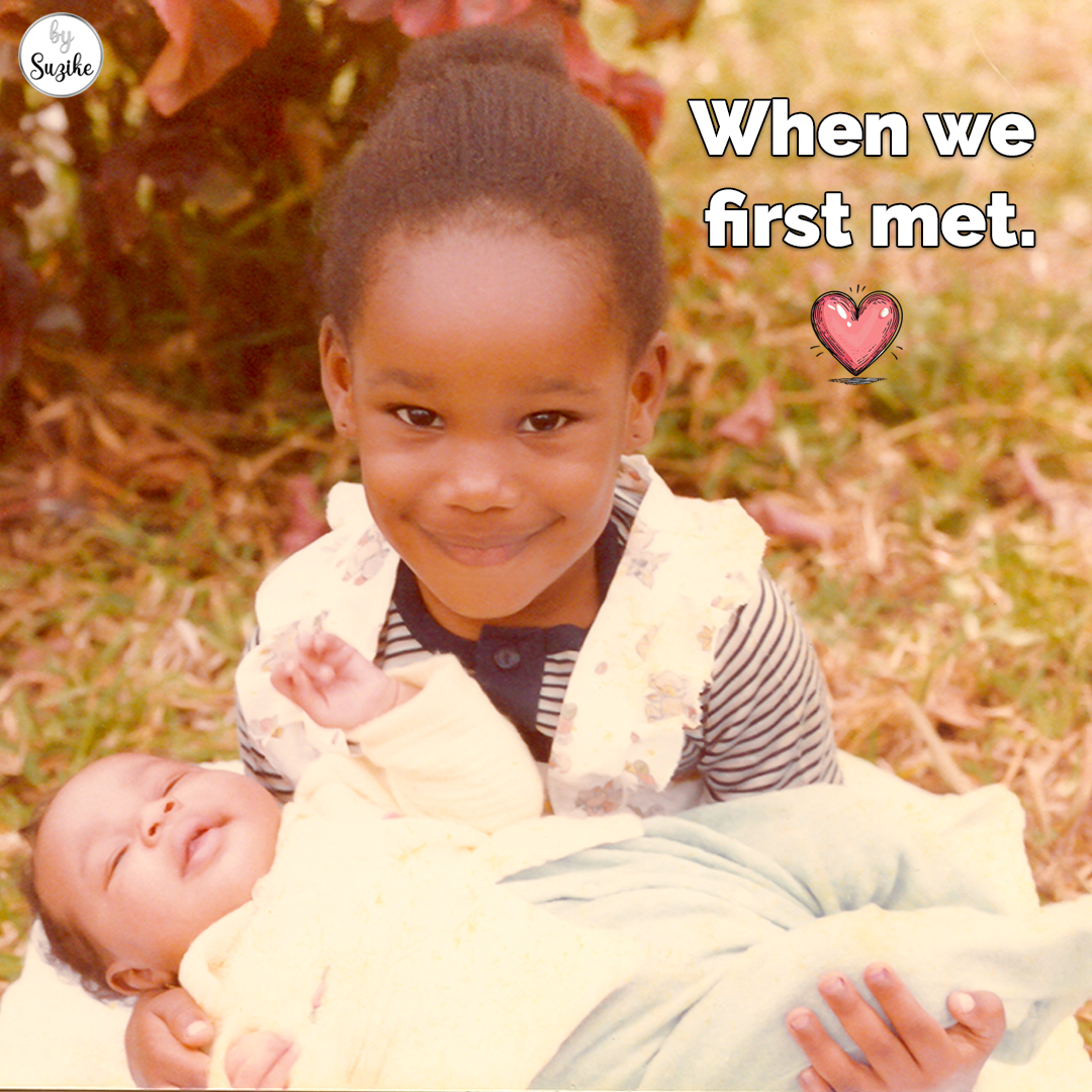 Little girl holding a newborn baby during their first meeting, smiling outdoors in a vintage family photo.