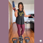Woman holding a 1 liter navy blue water bottle perfect for walking running and home workouts.