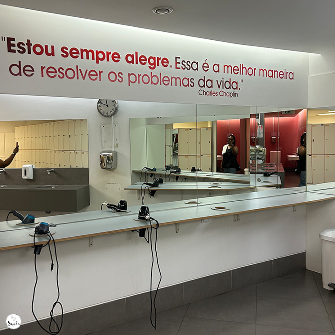 Modern locker room at Solinca Light Alvalade with a motivational quote on the mirror and hair dryers lined up along the counter.