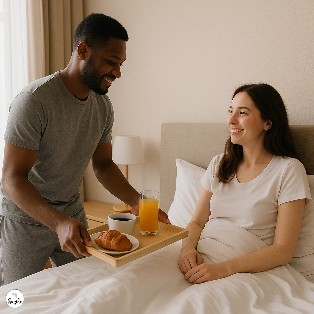 Breakfast in bed as one of the signs he loves you without saying it — a Black husband brings coffee and juice to his white wife in their cozy bedroom.