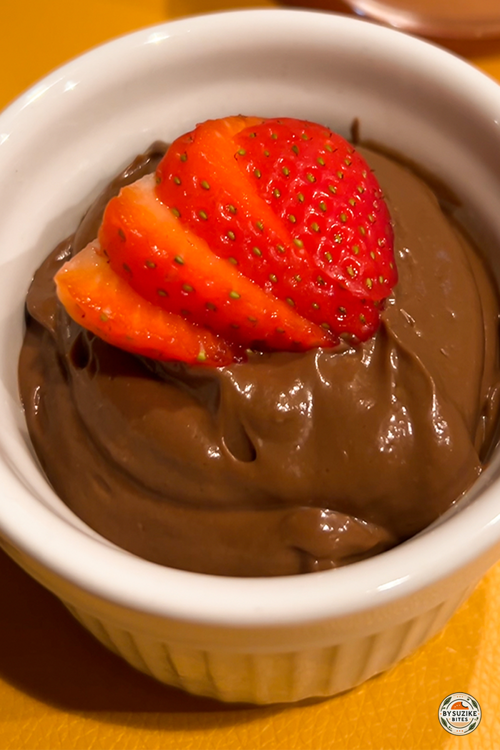 Low carb chocolate avocado mousse topped with fresh strawberries — creamy healthy dessert