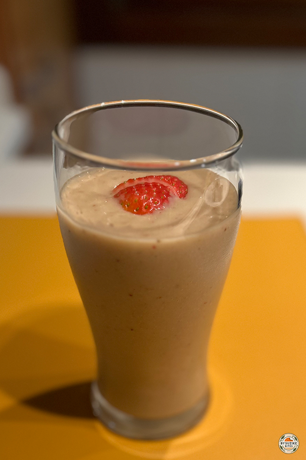Low carb strawberry protein smoothie topped with strawberry slices — creamy and refreshing drink