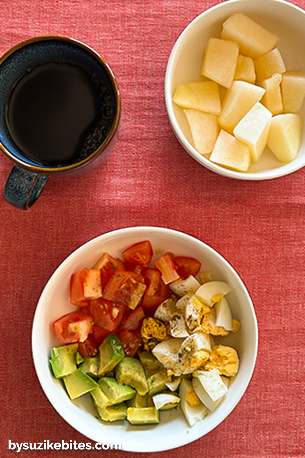 A healthy breakfast bowl with boiled eggs, avocado, and tomato, served with black coffee and melon cubes — part of my weight loss journey focused on balanced, low-carb meals.