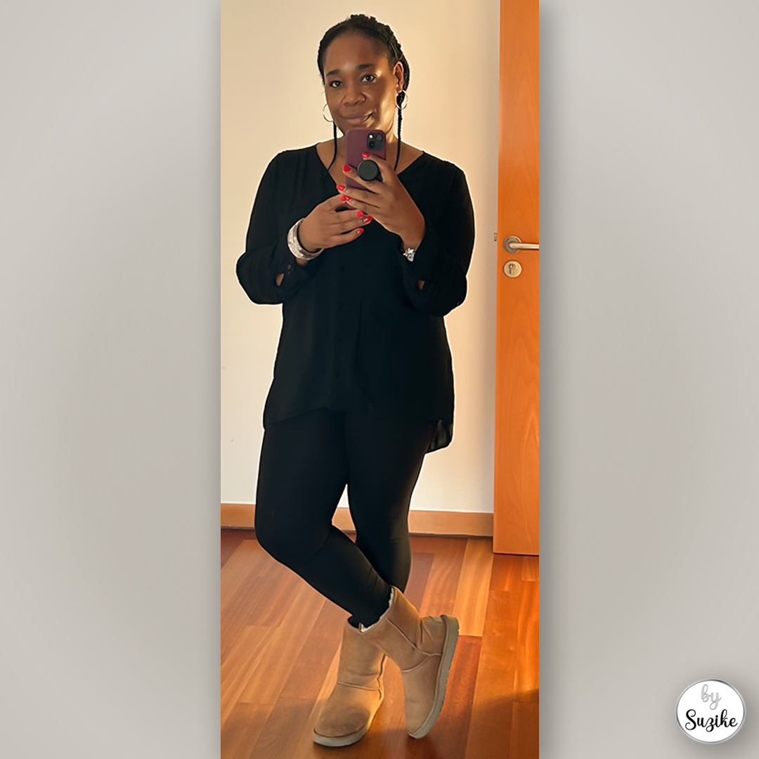 Suzike posing in a simple black outfit and cozy beige boots before going shopping.