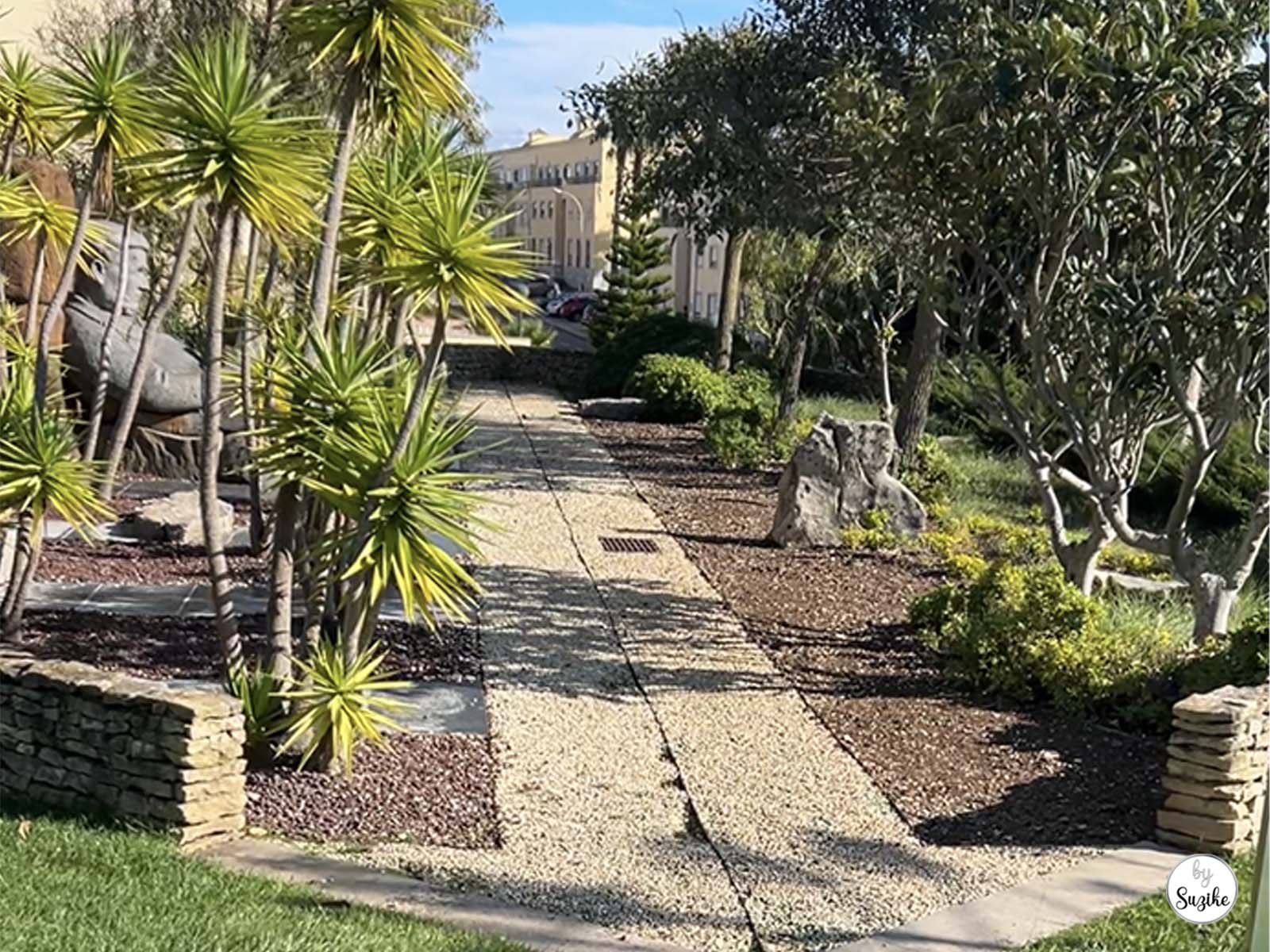 Pathway lined with palm trees and landscaped gardens at the Park of the Poets in Oeiras