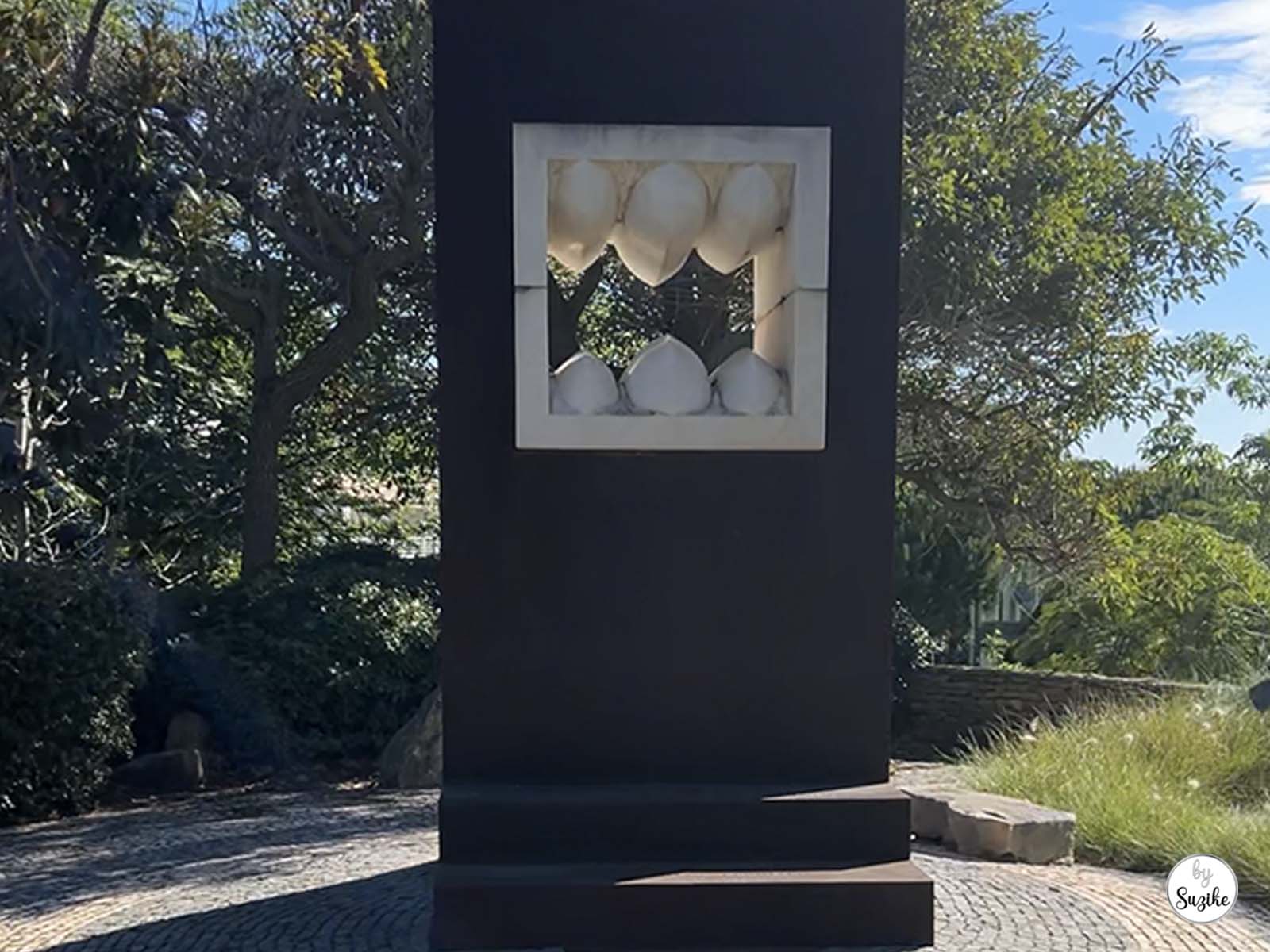 Outdoor art installation set within a dark rectangular structure at the Park of the Poets in Oeiras