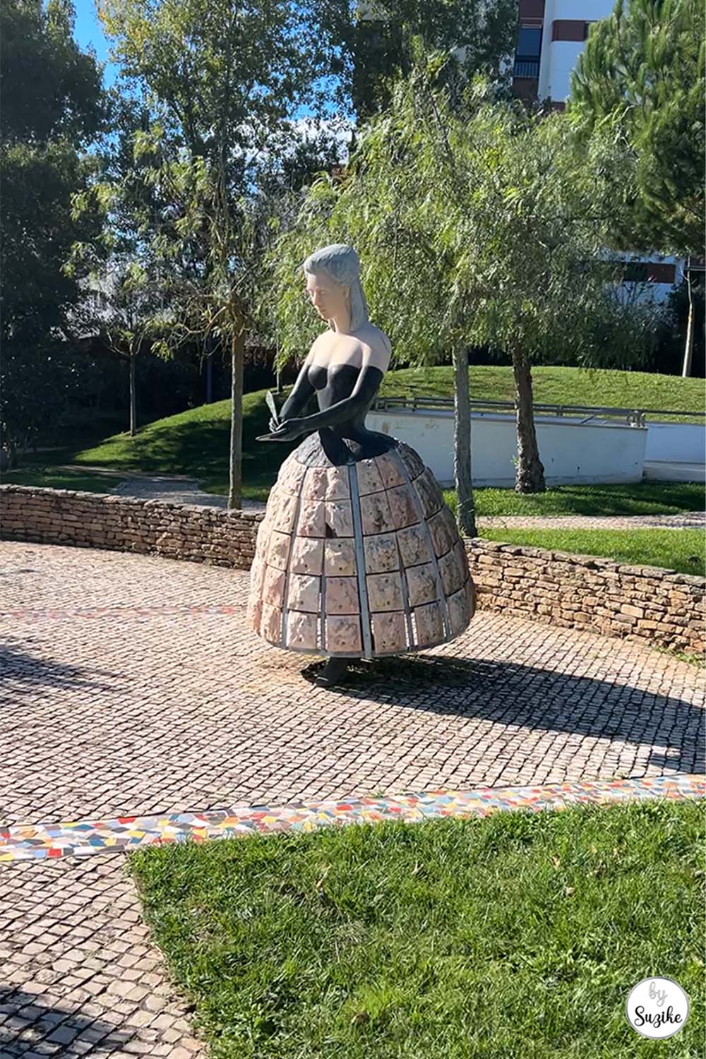 Female stone sculpture standing in a green outdoor area at the Park of the Poets in Oeiras