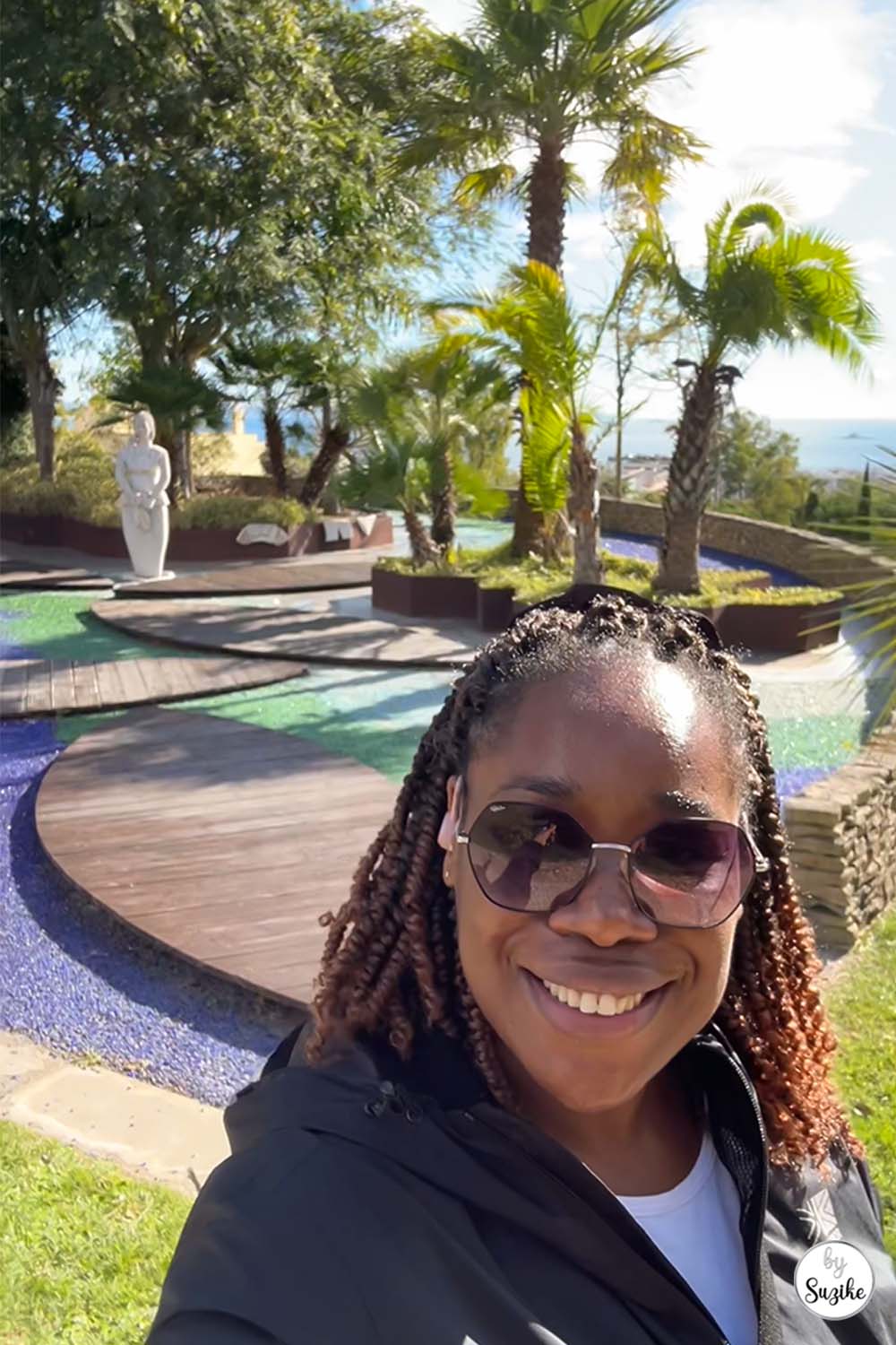 Person smiling during a sunny walk in the garden area of the Park of the Poets in Oeiras