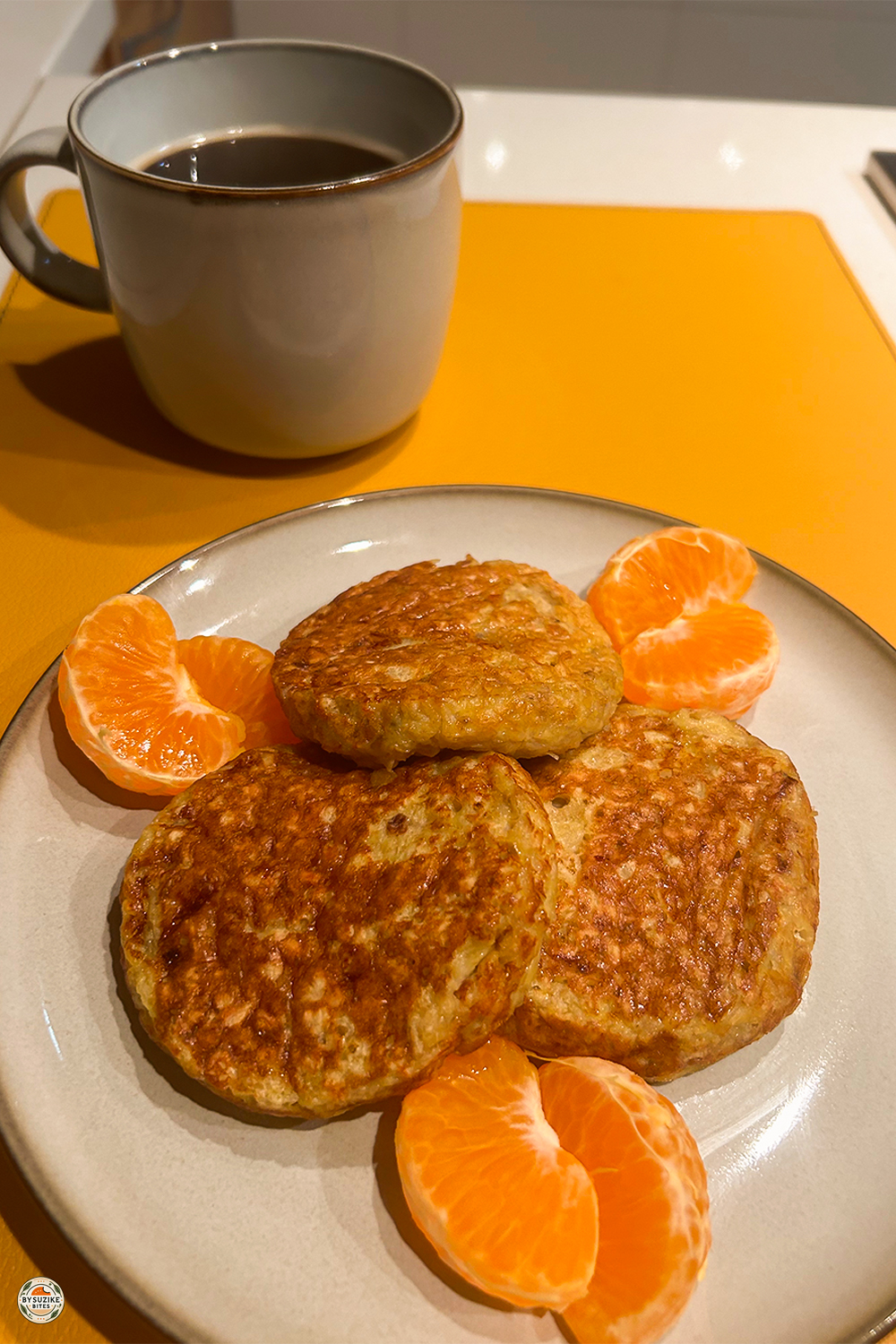 Oat and banana pancakes served with fresh tangerine and black coffee for a simple real-life breakfast