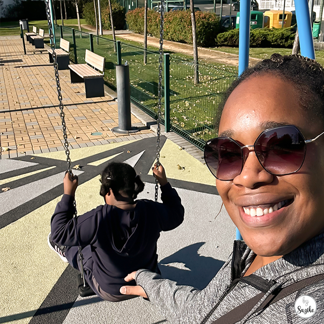 mother and daughter smiling at the playground on a sunny morning