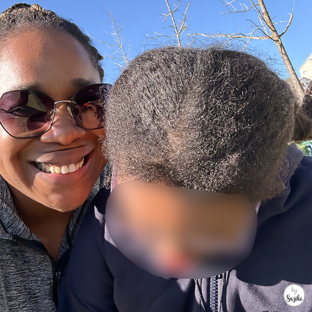 mother and daughter smiling together at the park, close-up
