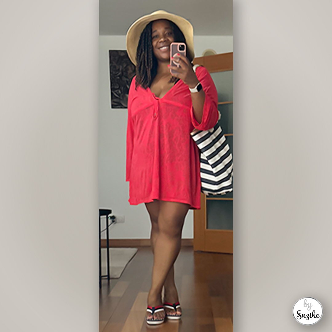 Suzike posing in a red summer dress with a beach hat and striped tote bag, real-life red summer dress outfit inspiration.