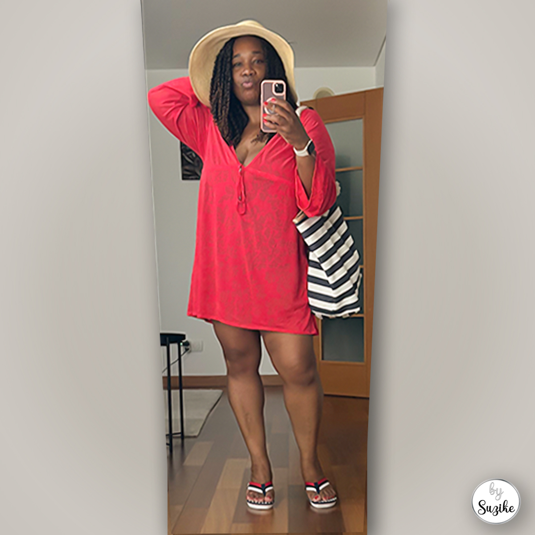 Suzike wearing a bright red swimsuit cover-up look with a beach hat, striped tote bag and sandals, real-life summer outfit inspiration.
