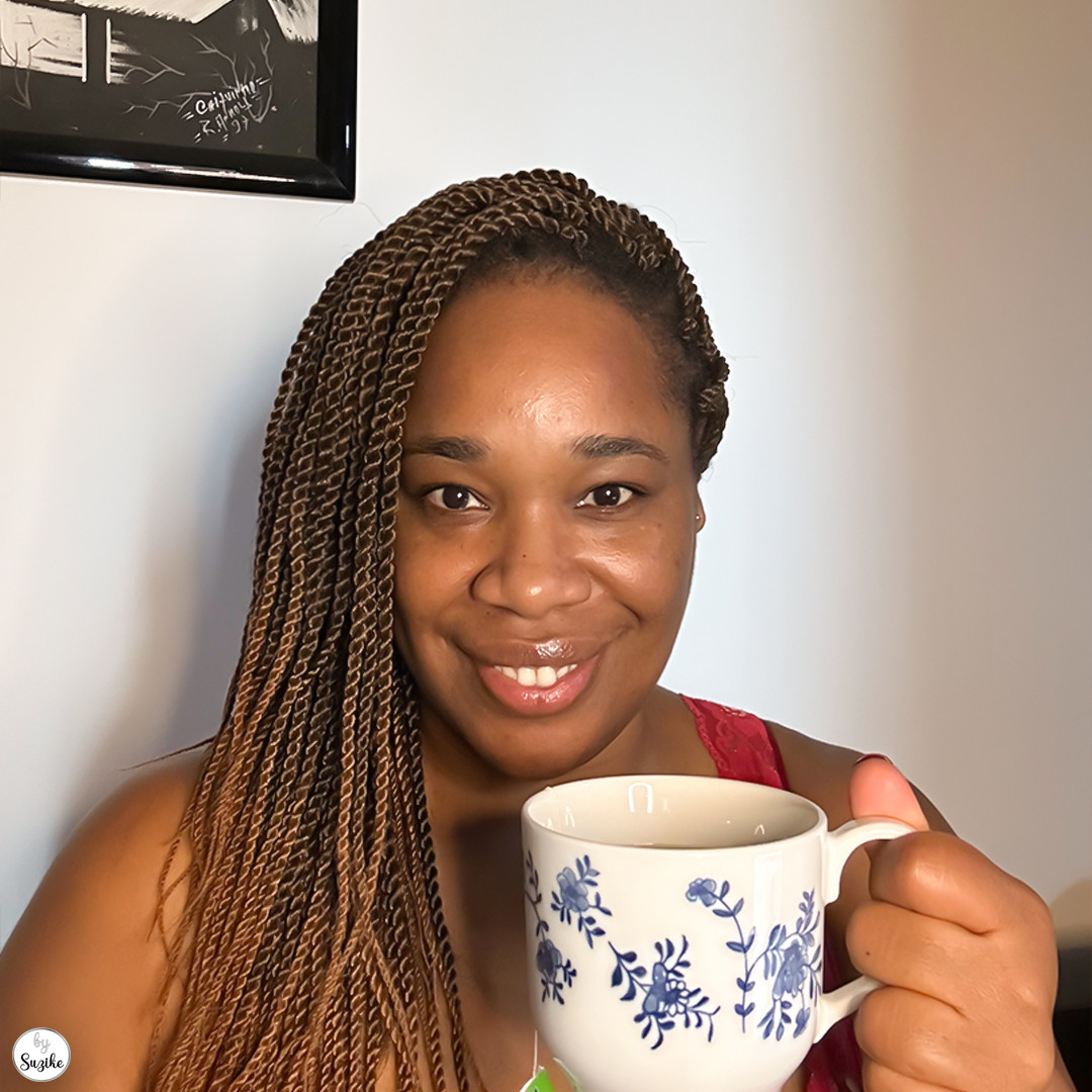 Woman smiling softly with a mug in hand during a personal reflection moment