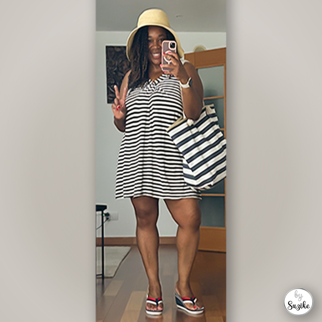 Suzike wearing a black-and-white beach striped dress with a summer hat, striped tote and sandals, mirror selfie full outfit.