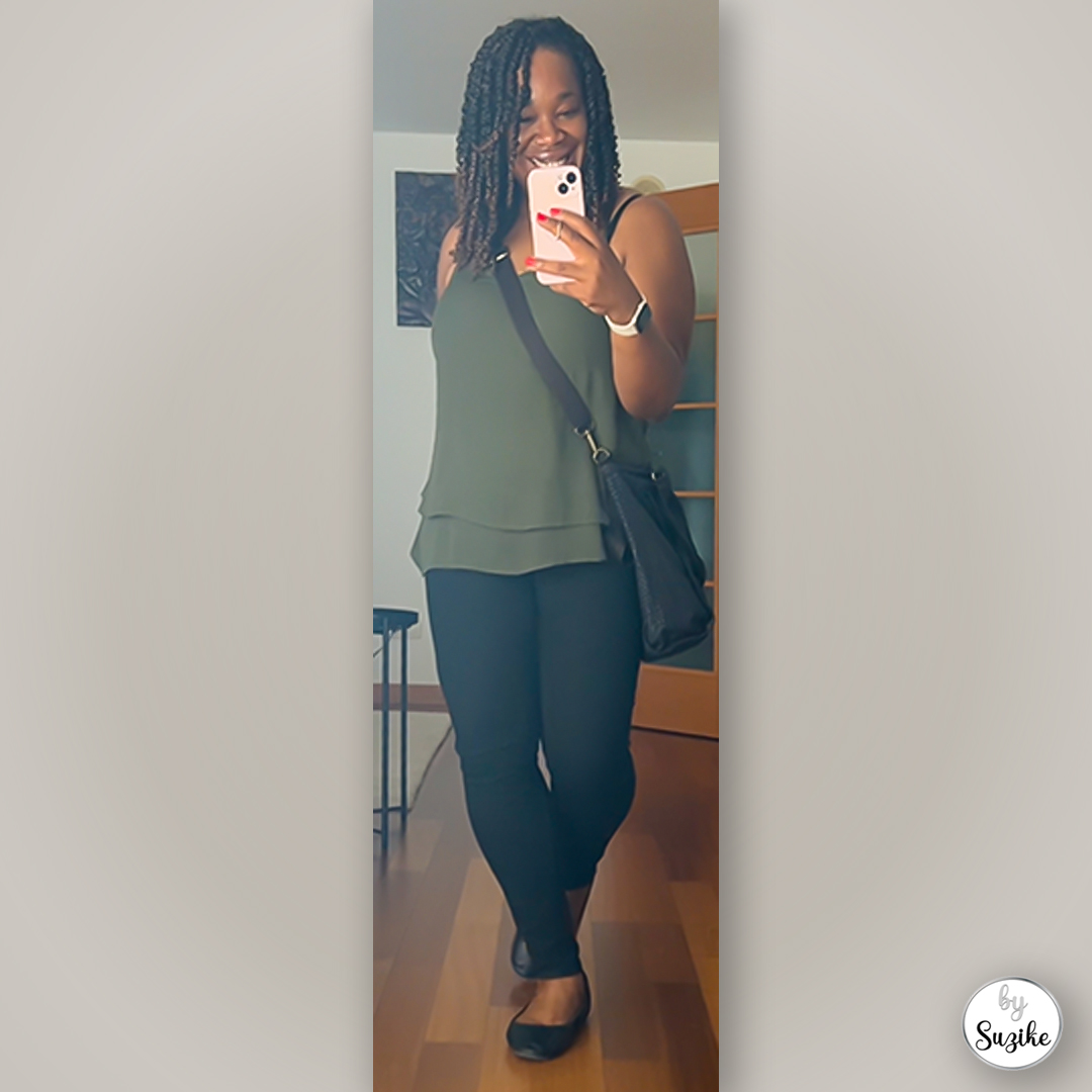 Mirror selfie of a green top and black pants outfit, featuring a crossbody bag and black flats in a simple real-life look.