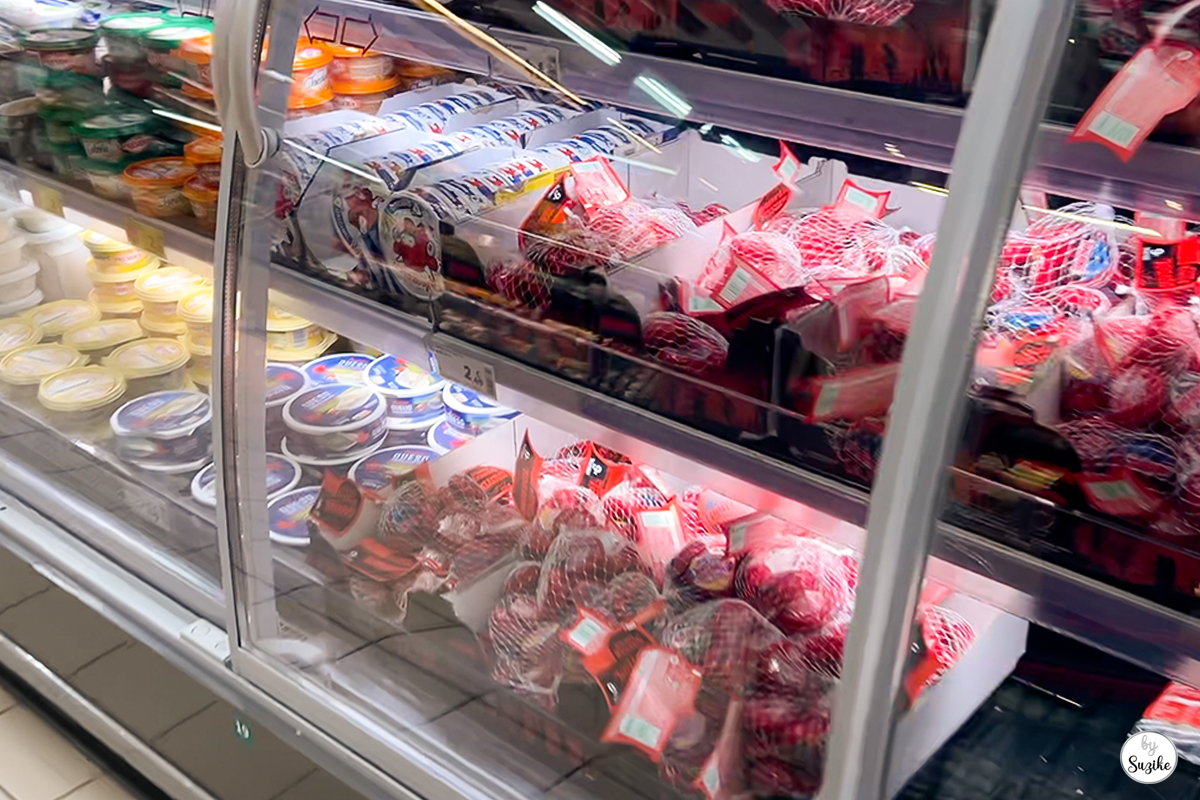Refrigerated dairy and deli section at the supermarket during Suzike’s quick grocery run.