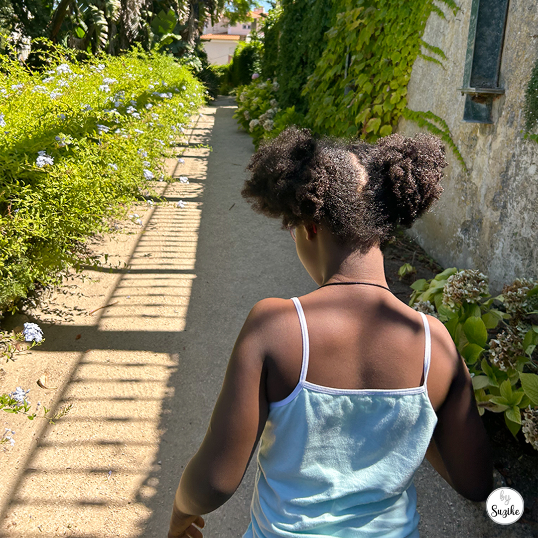 Felisberta walking along a narrow garden walkway during our Monteiro Mor Park and Theatre Museum visit.