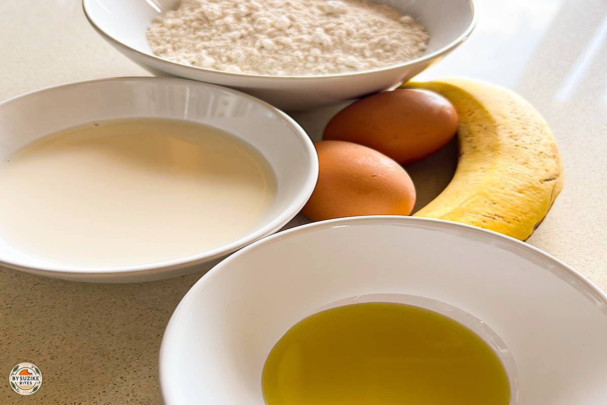 Ingredients for mini oat and banana pancakes: eggs, banana, oat flour, milk, and olive oil