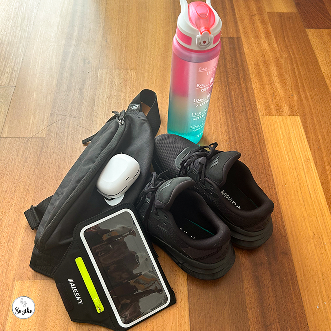 Running essentials laid out for my beginner running journey, including shoes, water bottle, earphones, and phone.