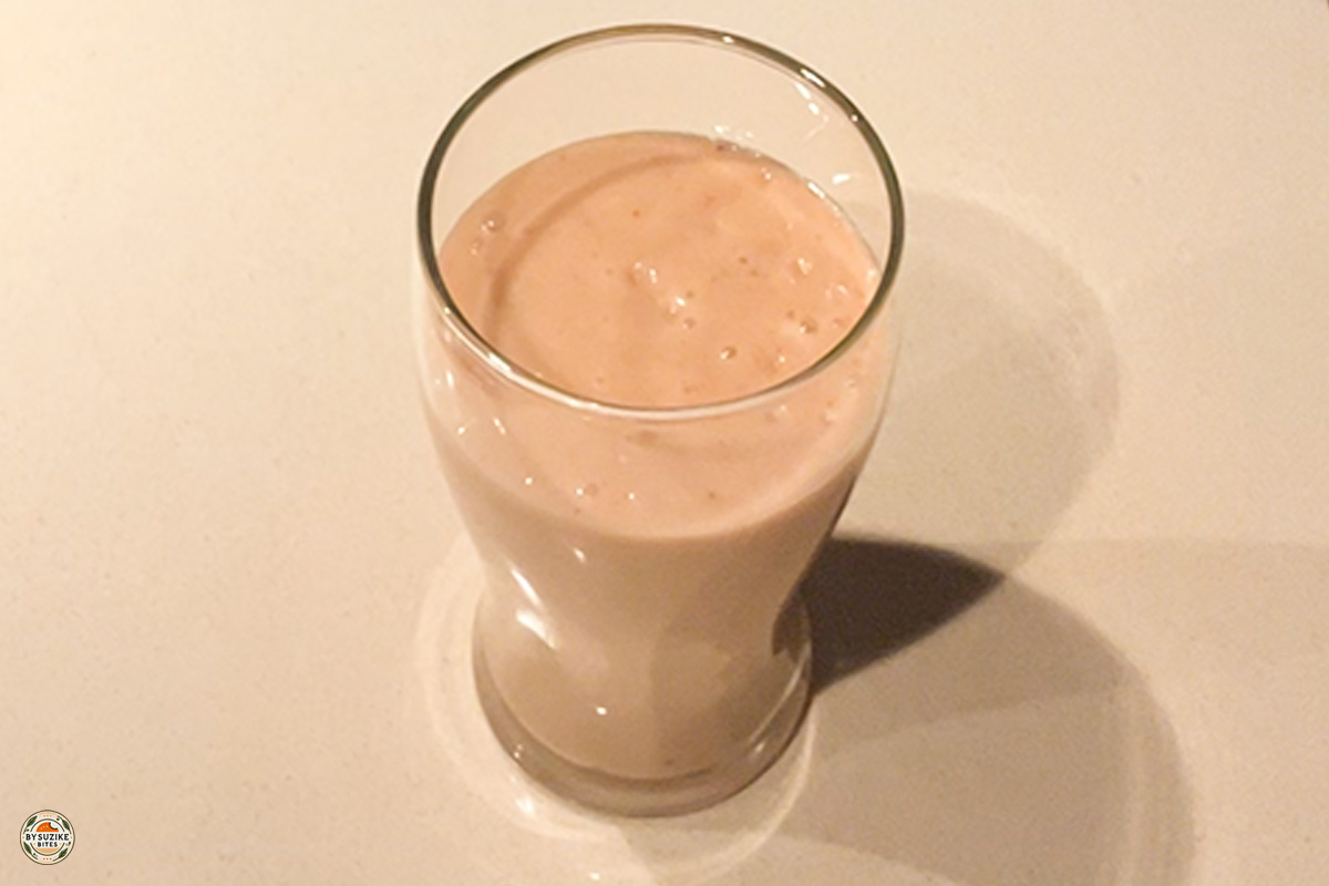 Glass of low carb strawberry avocado smoothie with a slice of strawberry on top