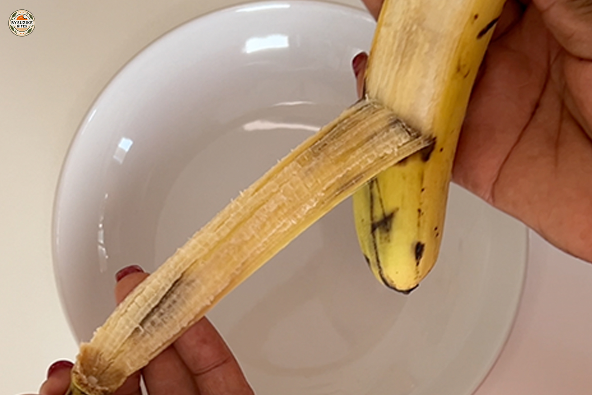 Peeling a ripe banana for fluffy banana oat cake.