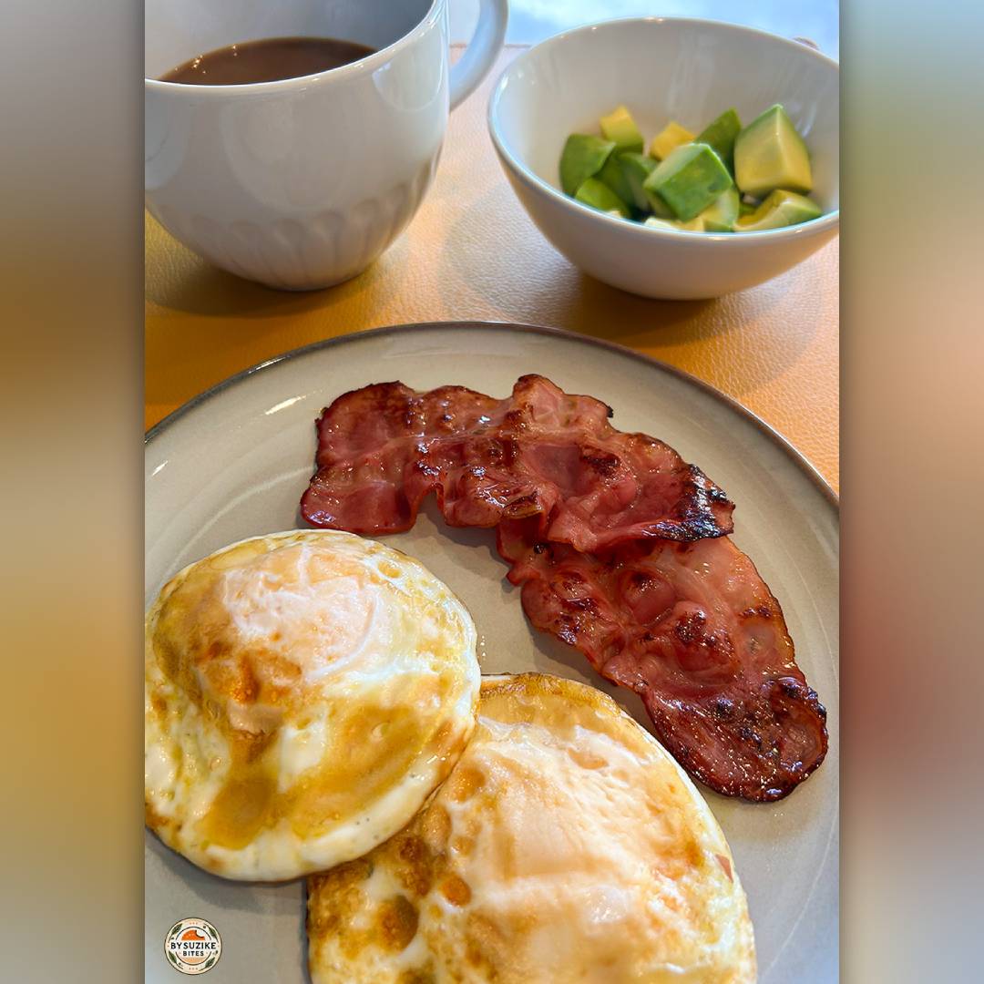 Black coffee next to a bowl of diced avocado, part of my low carb breakfast with eggs and bacon.