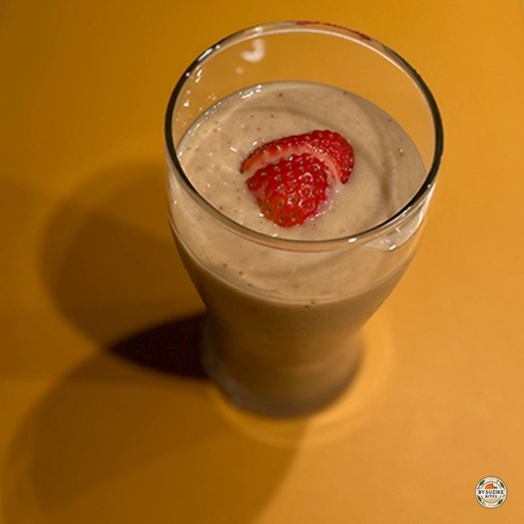 Glass of low carb strawberry avocado smoothie with a slice of strawberry on top