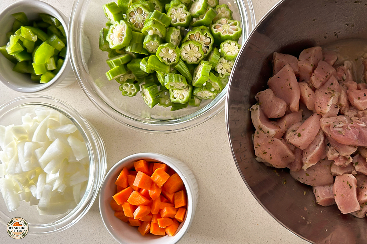 Ingredients prepped for pork with okra recipe including pork, okra, onions, carrots and bell pepper