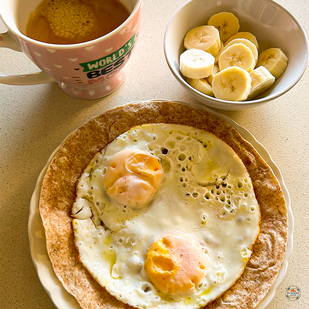 Real-life breakfast ideas: two fried eggs on a whole wheat tortilla with sliced banana and black coffee.