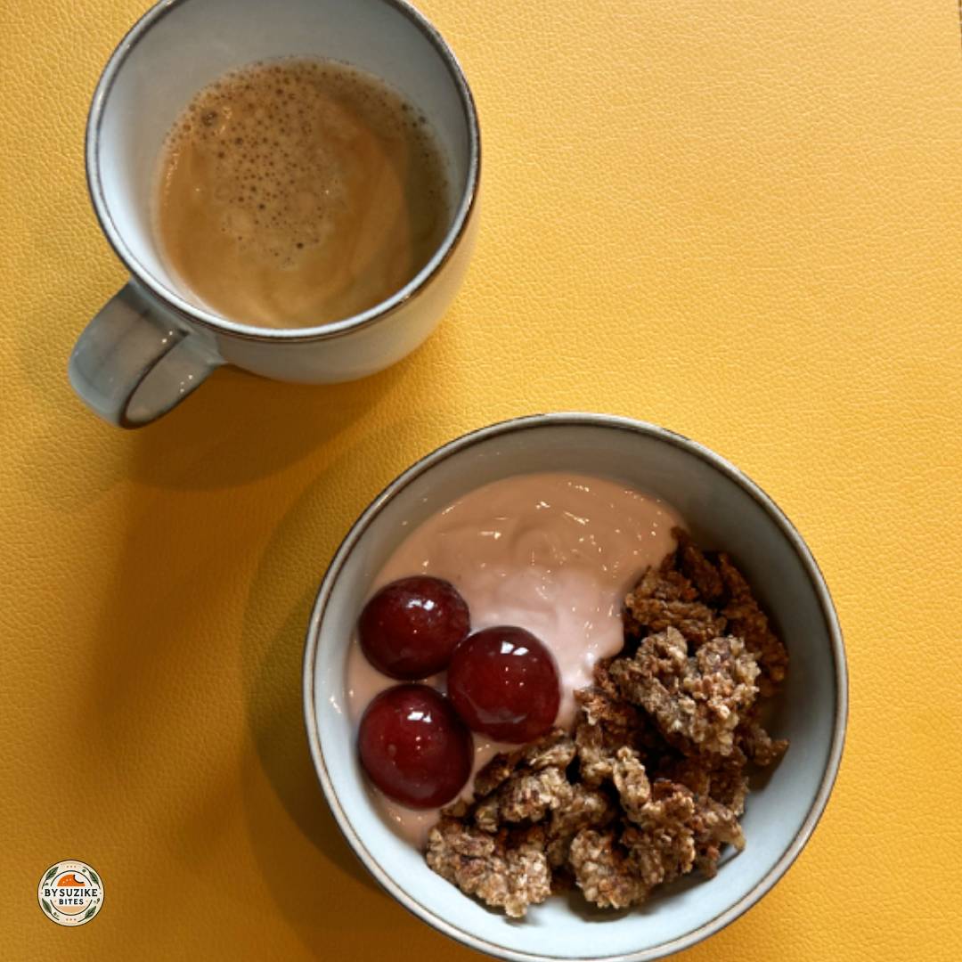 strawberry yogurt breakfast bowl and cinnamon oat crumble on a yellow placemat with coffee.