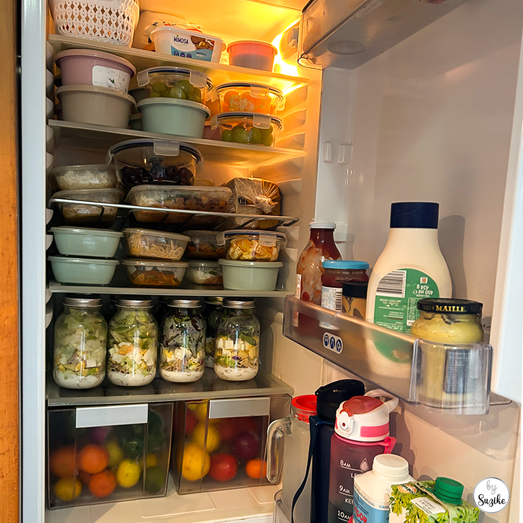 Weekly reset meal prep fridge stocked with jar salads, meal prep containers and fruit ready for the week.
