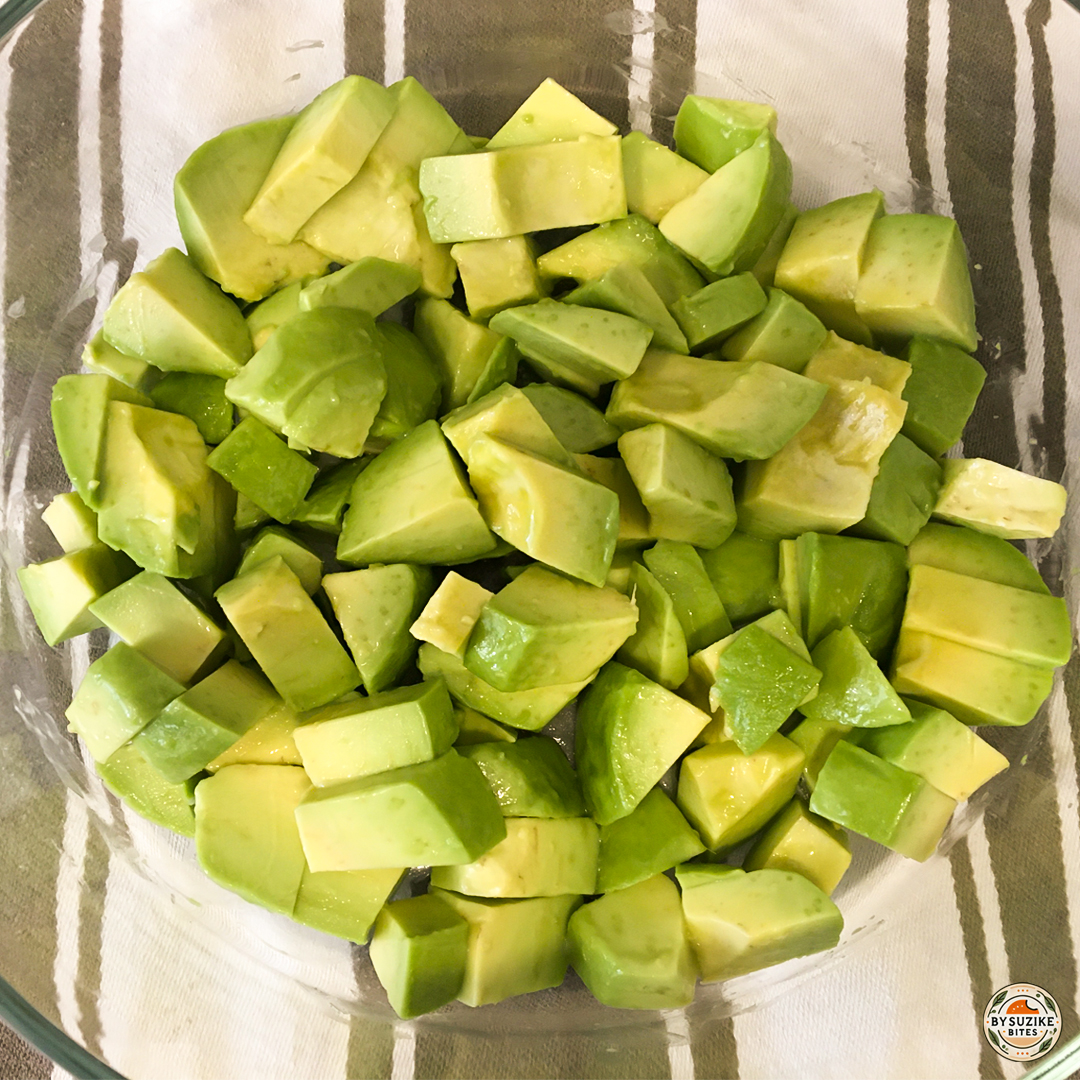 Chopped avocado in a glass bowl before mixing the avocado salad.
