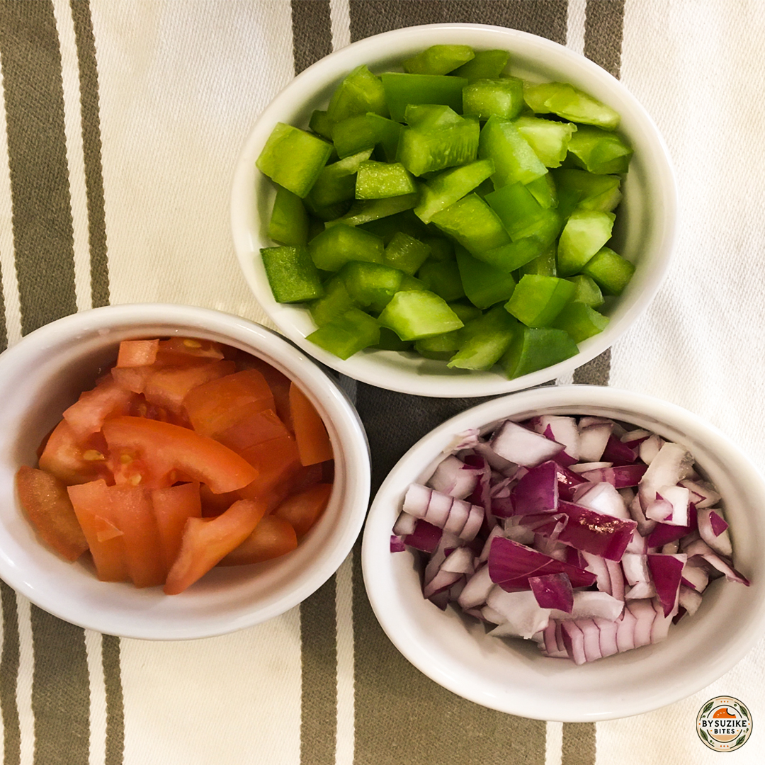 Chopped green pepper, tomato and red onion in bowls for avocado salad.
