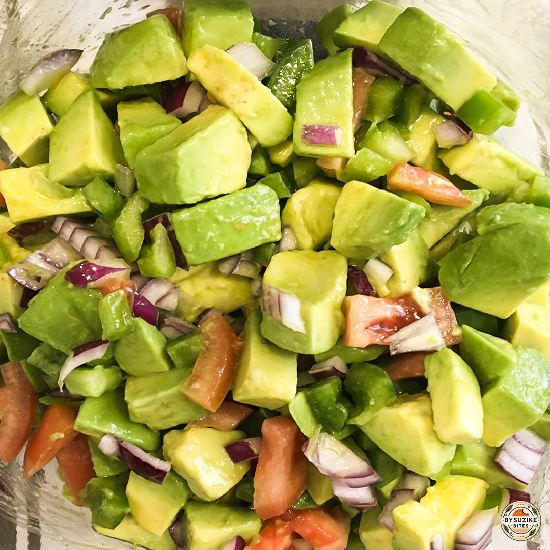 Close-up of mixed avocado salad with tomato, green pepper and red onion.