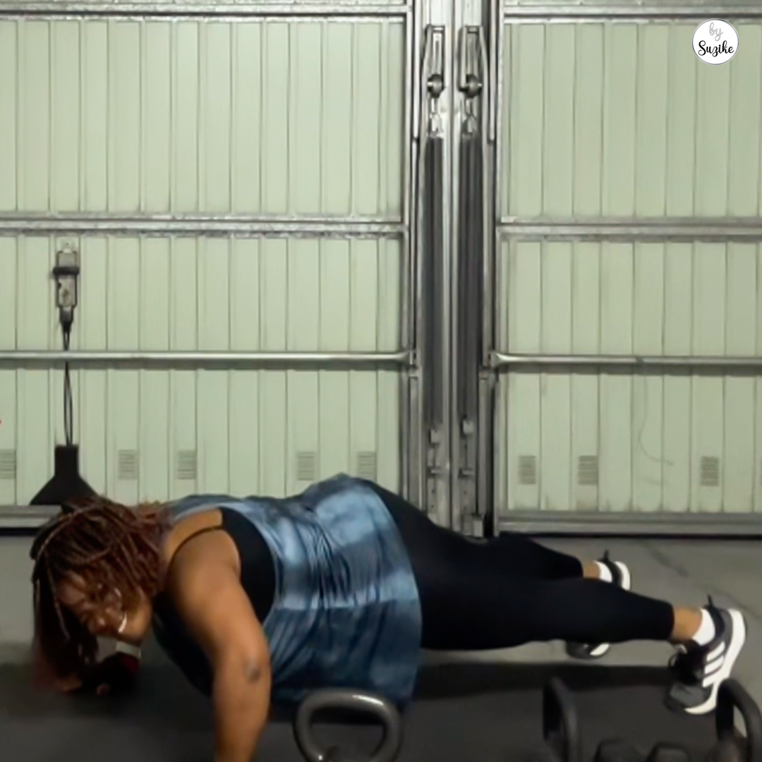 Woman training in a home gym during an upper body kettlebell workout, focused expression, indoor workout setting.