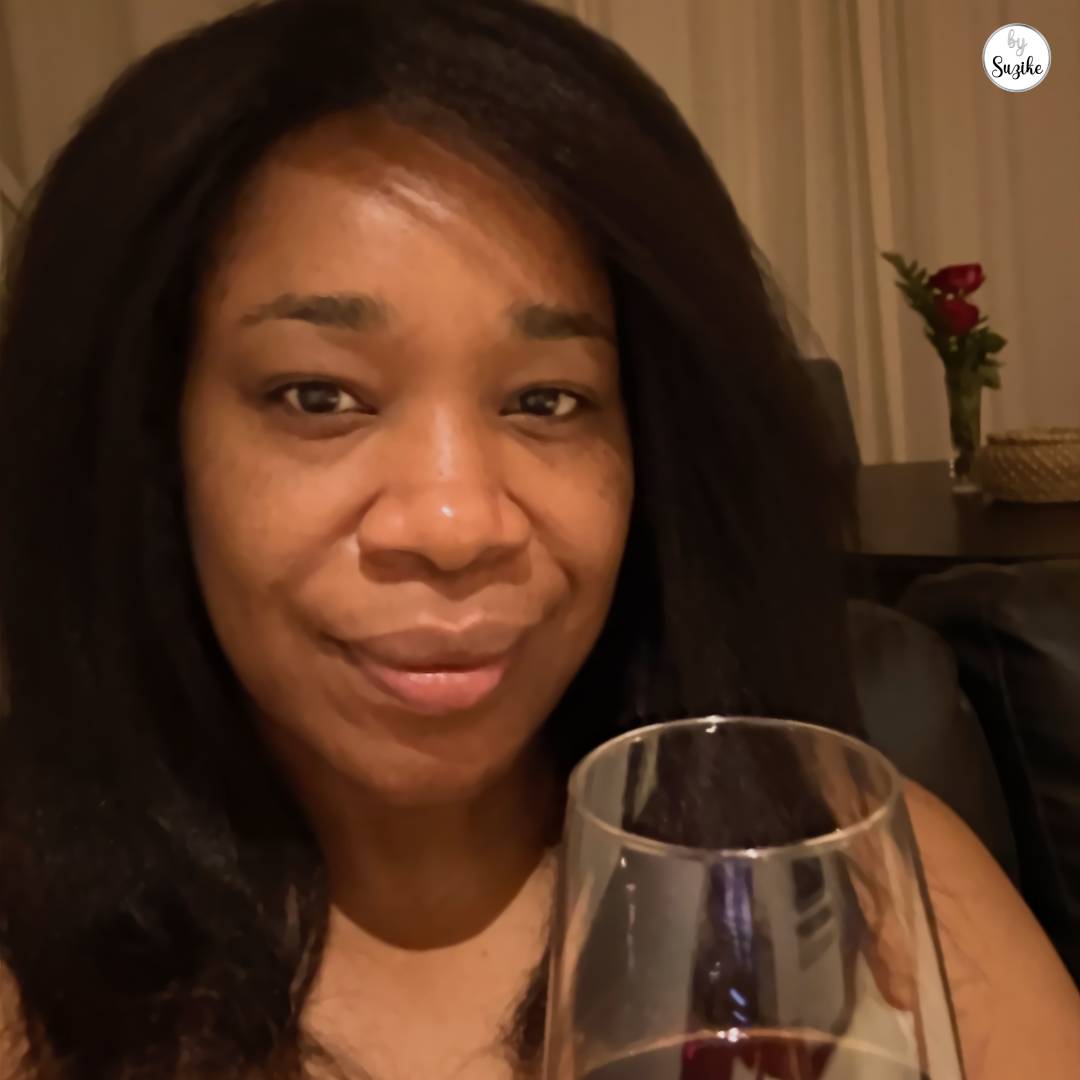 Cozy Valentine’s Day ideas at home for couples with warm lighting, a glass of wine, and a small bouquet of flowers in the background.