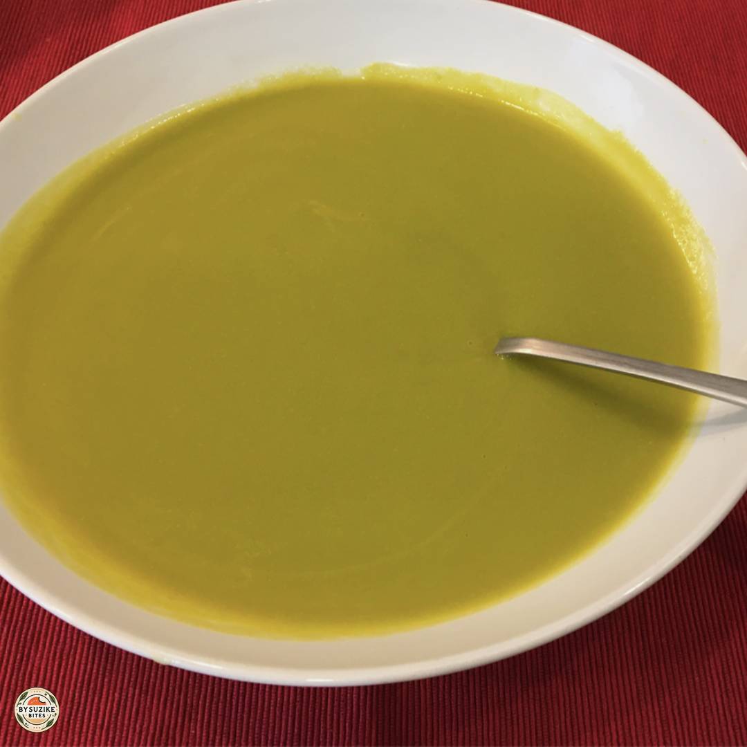 Creamy pea soup served in a white bowl, ready to eat.