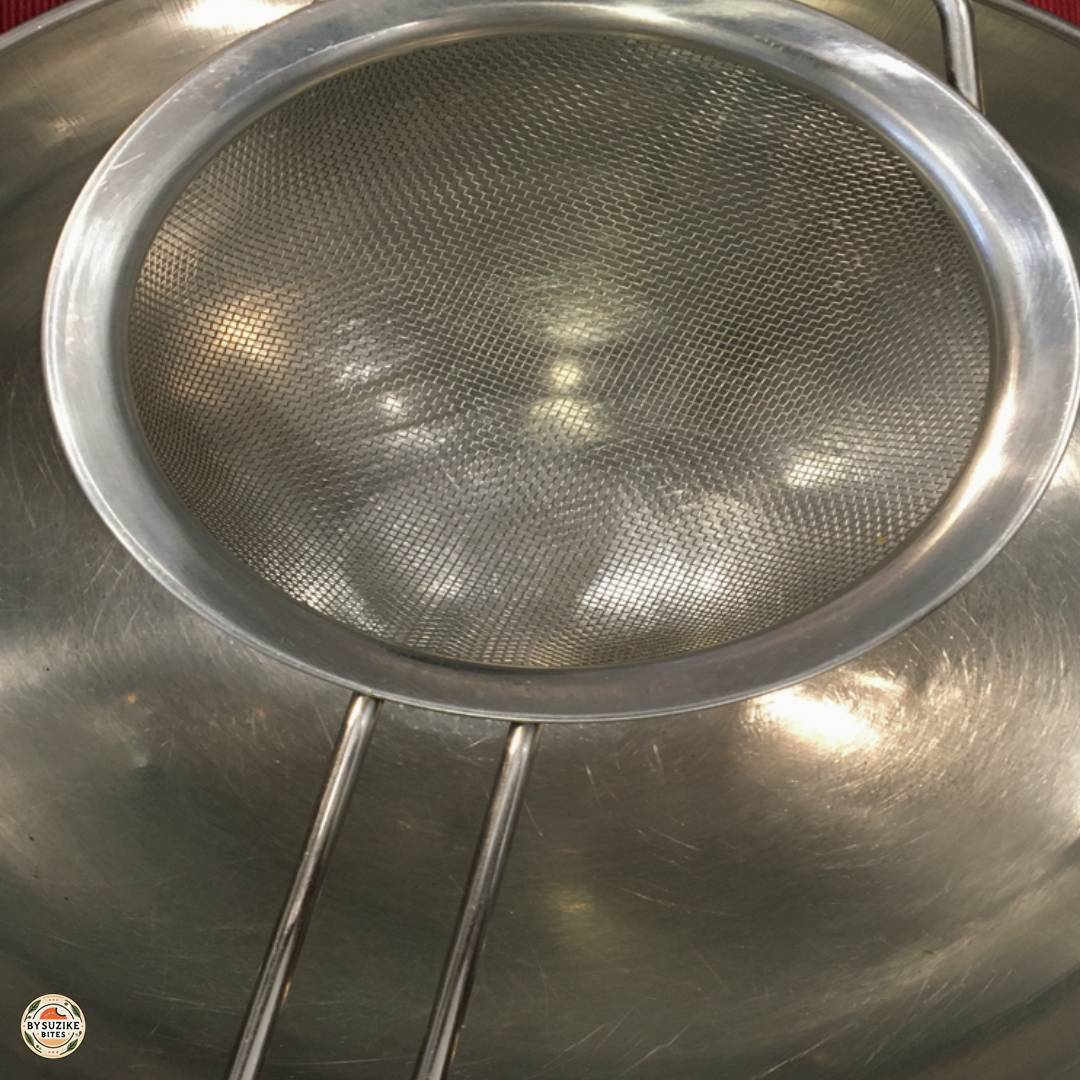 Fine mesh strainer set over a bowl to strain pea soup for extra smooth texture.