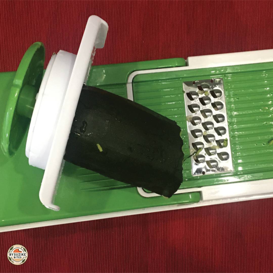 Grating zucchini using a vegetable chopper for keto zucchini tots.