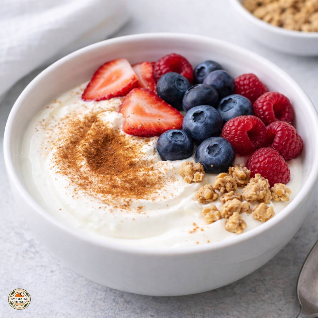 Cottage cheese vs greek yogurt for weight loss: Bowl of Greek yogurt topped with berries and cinnamon as a high protein breakfast idea for weight loss.