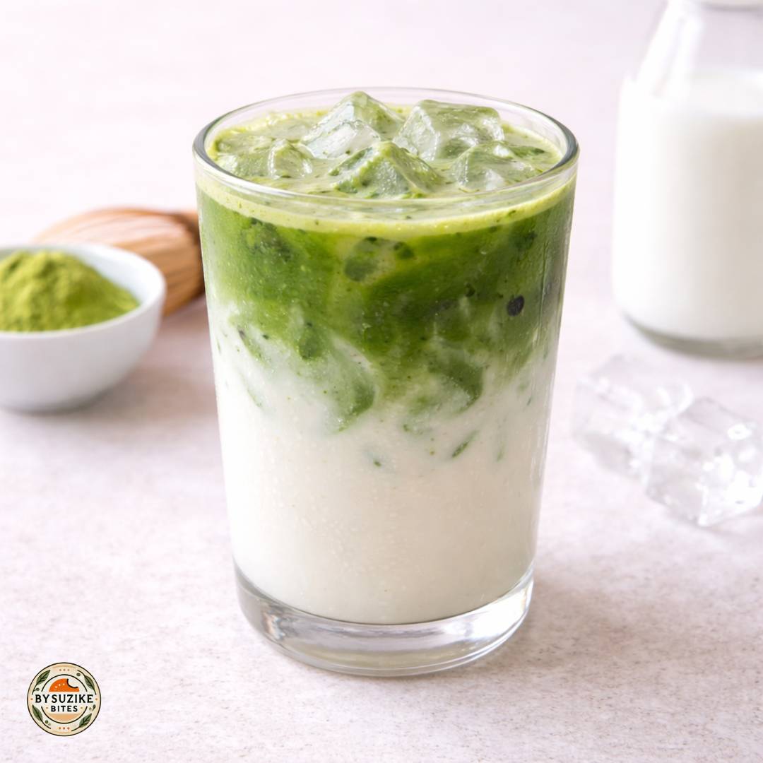 Iced matcha latte in a glass with ice on a bright neutral background