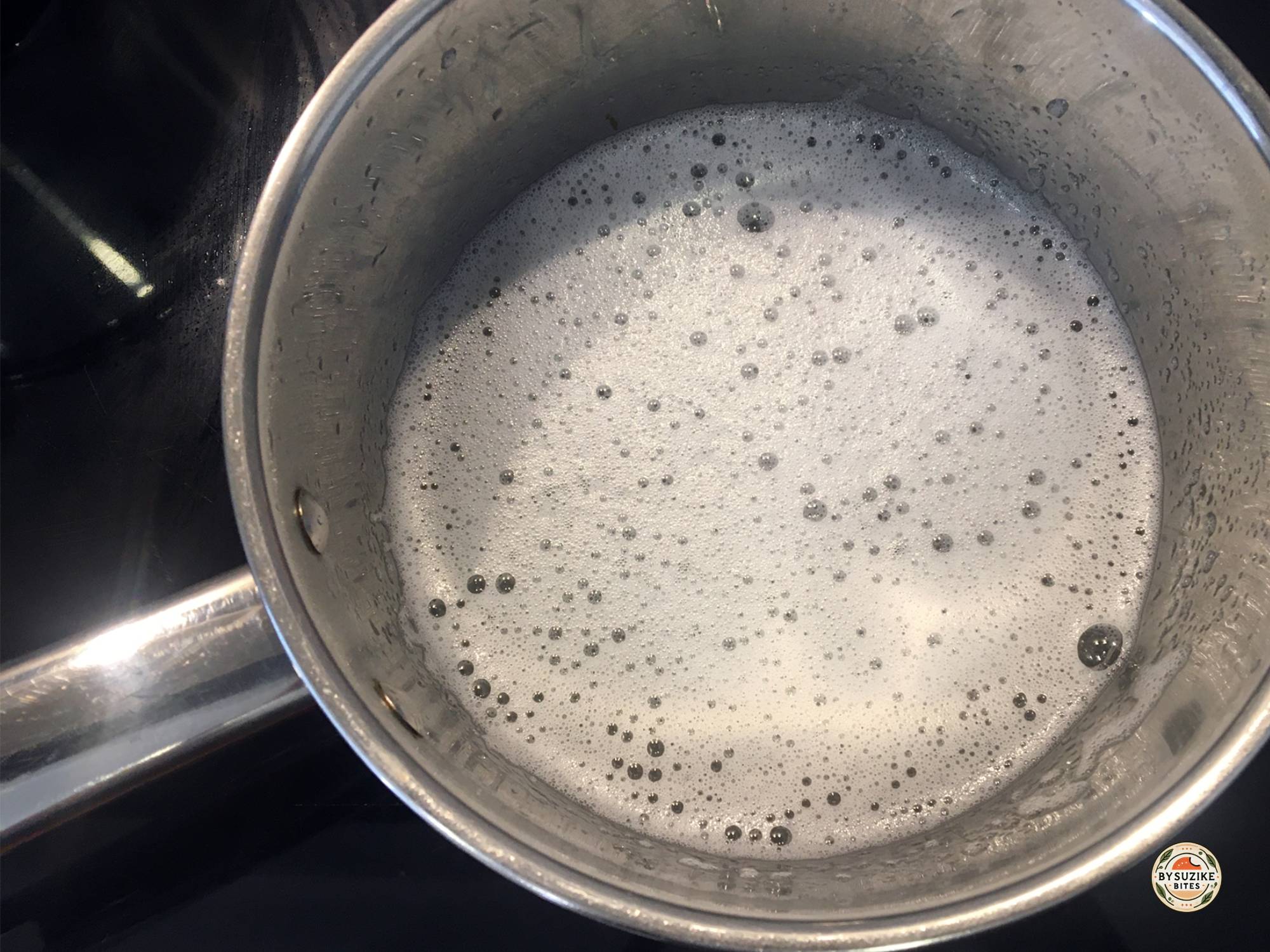 Gelatin mixture heating in a saucepan before whipping keto marshmallows.