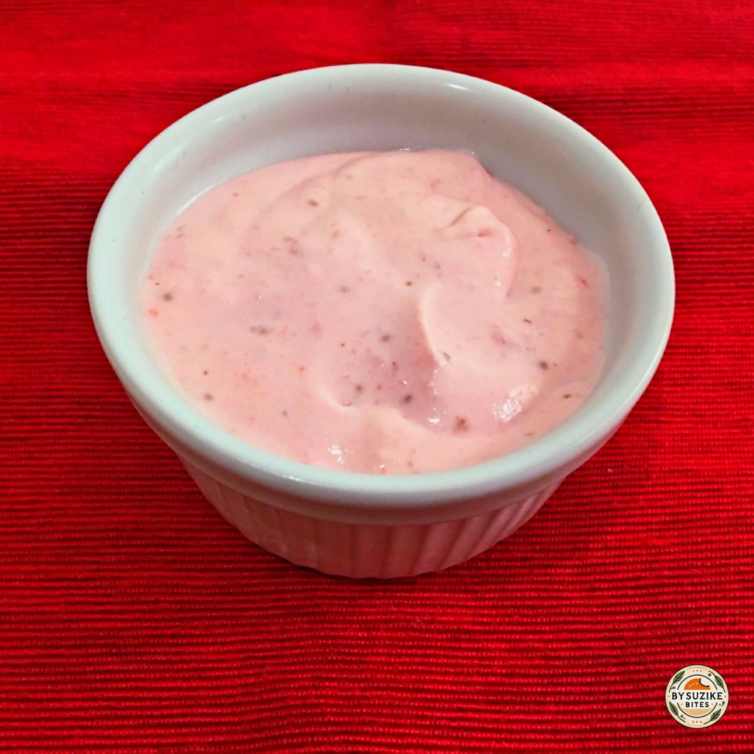 Keto strawberry mousse in a white ramekin, creamy low carb dessert on a red background