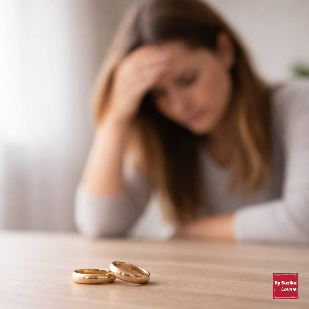 Can a marriage survive cheating, two wedding rings on a table with a distressed woman in the background.