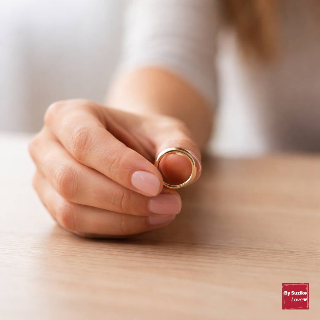 Can a marriage survive cheating, close-up of a woman holding her wedding ring off her finger.